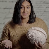 women with short brown hair holding a fake brain