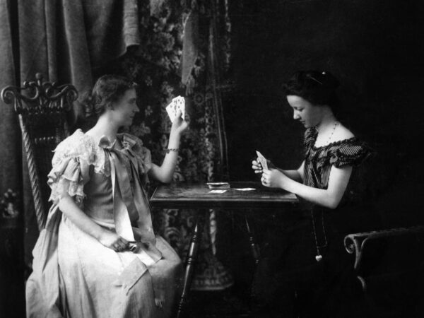 black and white picture of two women sitting across from each other playing cards
