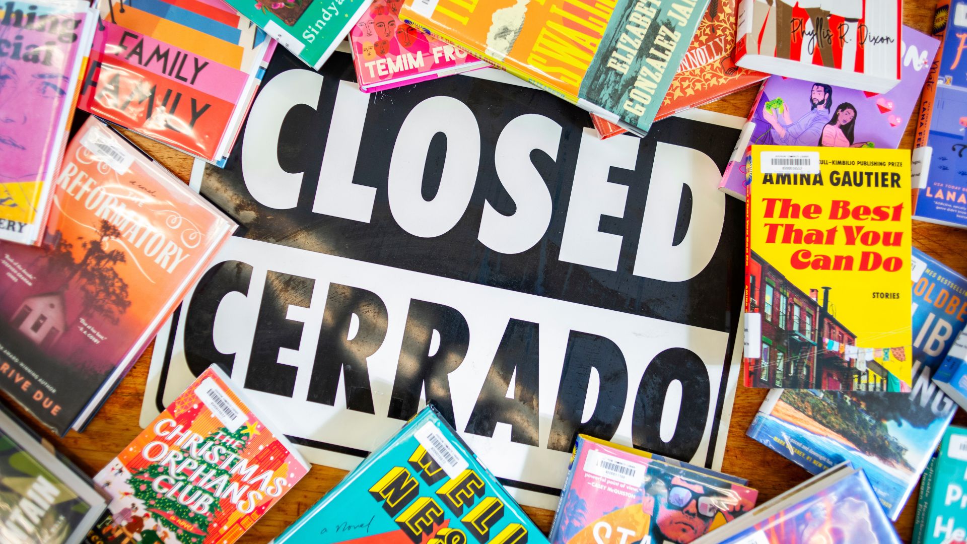 black and white "Closed/Cerrado" door sign surrounded by colorful book covers