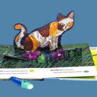 An open children's book with a pop-up paper cat