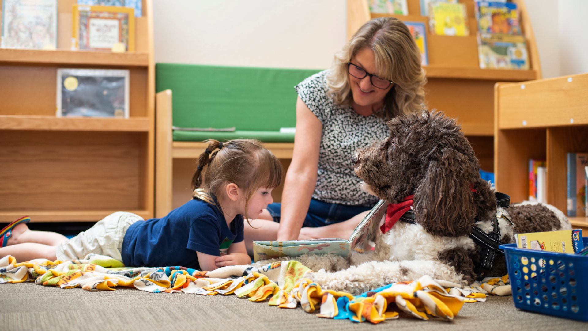 dog, woman, and child reading at library